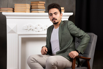 Portrait of a young business man sitting on a chair thinking what to do