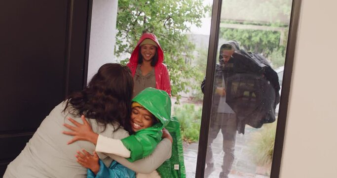 Family visiting grandma at her home, spending time together and bonding. Happy grandmother opening door, welcoming her loving children and hugging her excited grandkids arriving on a rainy day.