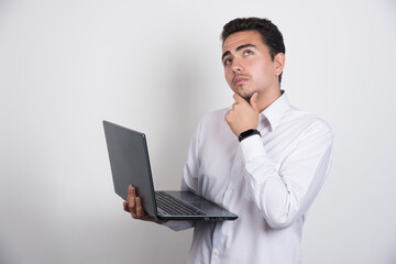 Businessman with laptop thinking on white background