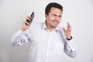 Businessman trying to get away from telephone on white background