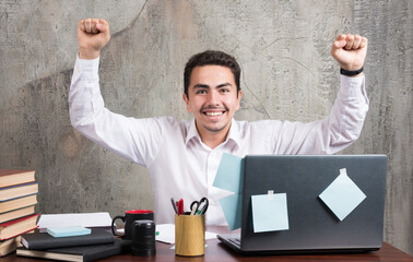 Young businessman having best moments at the office desk