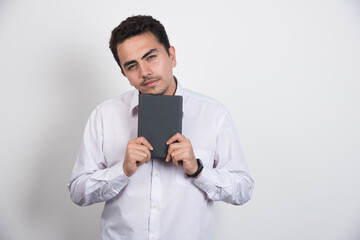 Young businessman with notebook posing on white background