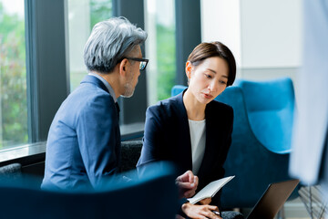 オフィスで話をするスーツを着た日本人女性