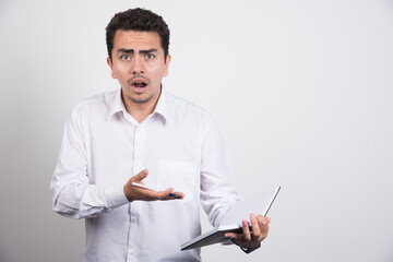 Mad businessman pointing at mistake on white background