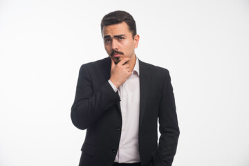 A businessman in dress code looks doubtful