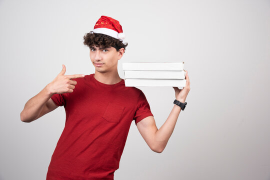 Young deliveryman with pizza boxes giving thumbs up