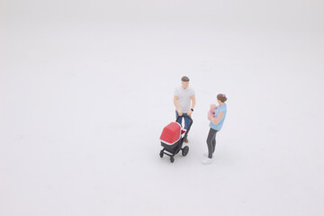 mini of Mother and father walking outdoors and pushing baby in pram