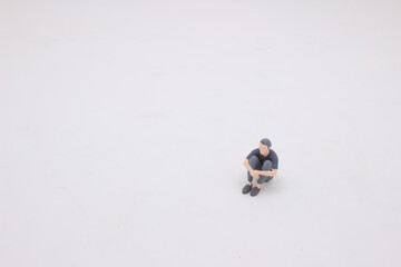a mini figure of homeless male begging