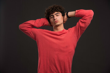 Young model with curly hairs holding his head