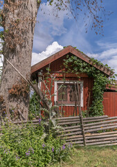 Façade of a small red house in a park a sunny summer day in Stockholm