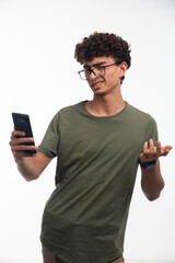 Young boy with curly hairs checking awkward messages