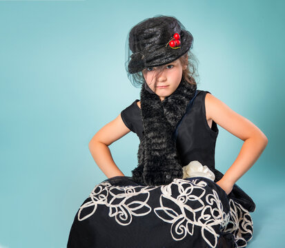 Little girl with attitude in steampunk cosplay costume with vintage hat and veil