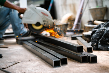Steel welders welding large warehouse roof steel structures with electric welding tools.