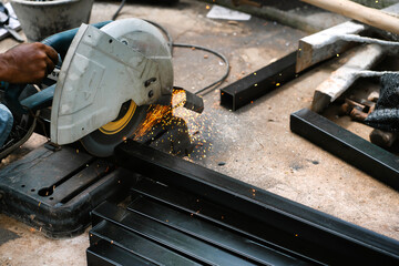 Steel welders welding large warehouse roof steel structures with electric welding tools.