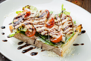 Bruschetta with chicken meat on plate on wooden table