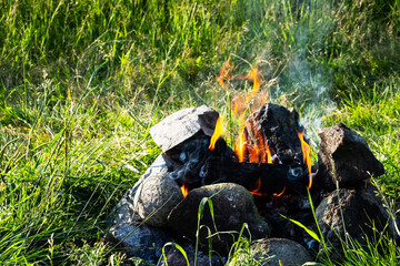 Bonfire burns in forest. Tourist fire for cooking at nature.