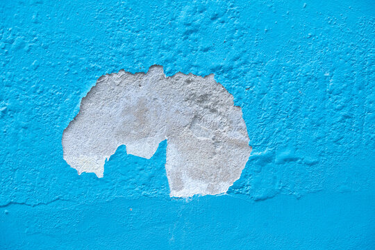 the house paint cracked on the blue wall. 