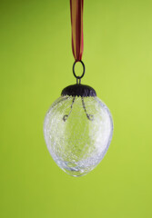 Closeup of a glass lightbulb against a green copyspace background. Zoom in on lightbulb details...