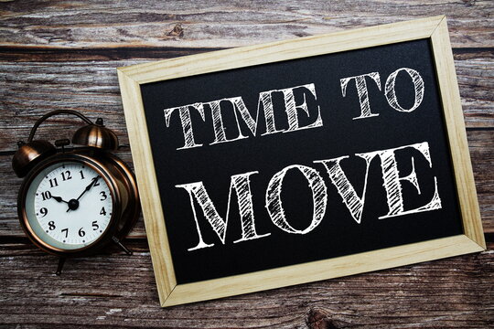 Time to Move word with alarm clock on wooden background