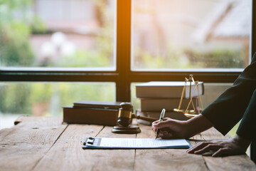 Close up of lawyer's hands is singing on agreement paperworks. On table in the office.