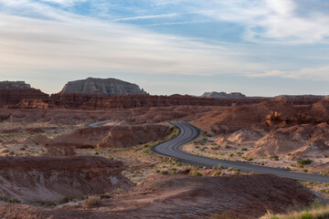 Scenic Road surrounded by Red Rock Mountains in the Desert at Sunrise. Spring Season. Goblin Valley State Park. Utah, United States. Nature Background.