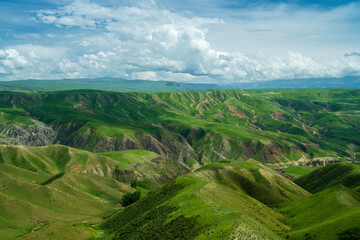 Fototapeta premium The Kalajun grassland in Xinjiang, China. Landscape with hills and clouds.