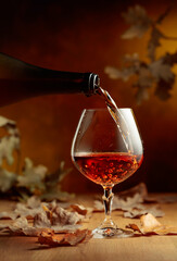 Cognac is poured into a glass from a bottle.