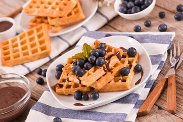 Waffles with blueberries and chocolate cream. 