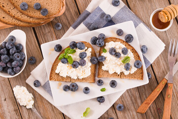 Rye bread with cottage cheese, blueberries and honey.
