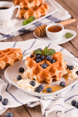 Waffles with blueberries and whipped cream.