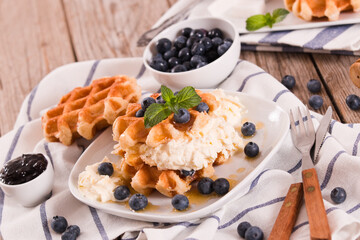 Waffles with blueberries and whipped cream.