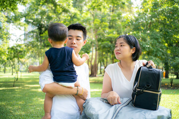 Family with son enjoying relax picnic in green nature park