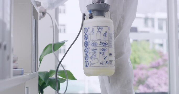 Closeup Of Sanitation Worker Disinfecting The Inside Of An Office Building, Wearing Biohazard Suit For Hygiene And Holding Disinfectant Tank For Cleaning. Protection During Covid Lockdown Pandemic