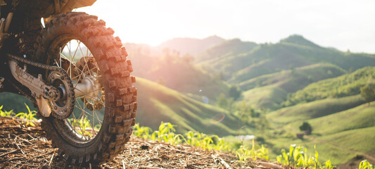 Part of a motocross wheel on a mound, with sunrise.beautiful mountain scenery backdrop adventure...