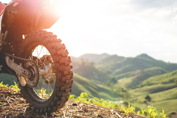 Part of a motocross wheel on a mound, with sunrise.beautiful mountain scenery backdrop adventure...