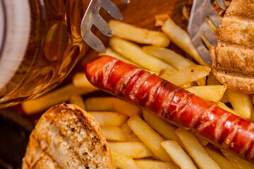 American hot dog with sausage, potatoes and a glass of beer