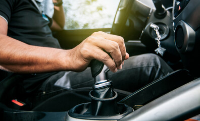 Concept of hand grabbing the gear lever of a car with copy space, Close-up of driver hand on the...