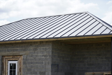 A new house, the roof of which is made of metal. Cottage in the countryside. roof made of modern materials.