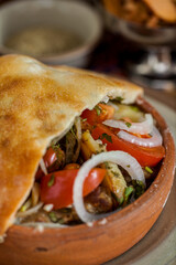 Oven baked vegetables in a pot under dough and a glass of red wine