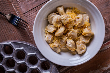 Homemade boiled dumplings fried in butter with garlic and grated cheese.