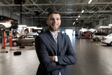 Manager for the acceptance of cars for repair. A man stands against the background of a service station