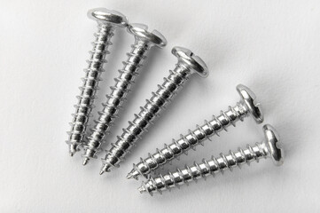five screws on white paper. detailed macro photo. Self Tapping Screws. Set of screw