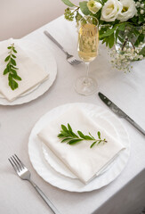 Wedding teble decoration with white flowers, glasses and white napkins. Elegantly decorated table at a wedding reception. Festive table setting. The wedding decor.