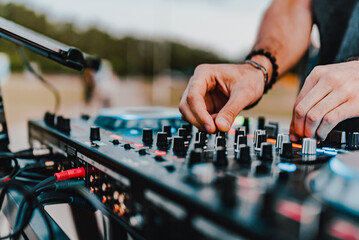 DJ Hands creating and regulating music on dj console mixer in concert outdoor - obrazy, fototapety, plakaty