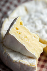 Sliced ​​piece of Camembert. Camembert close-up. Macro photography of cheese for the cover. Camembert advertisement. Cheese for the cover. Brie advertisement. Brie close-up. Cheese with mold close-up.