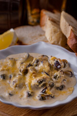 Mussels in creamy sauce with cheese and a glass of beer