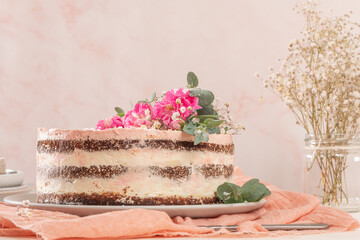 Chocolate naked cake with fresh roses and swiss buttercream on a white background