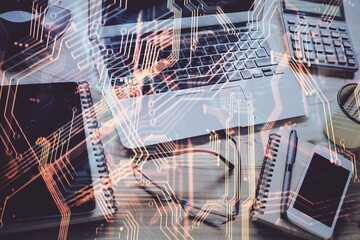 Computer on desktop in office with technology theme hologram. Double exposure. Tech concept.