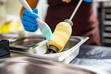 hand of chef baker making Trdlo or Trdelnik, Traditional tasty baked Czech Republic. street food
