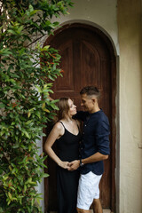 Happy loving couple hugging on the background of the house in the garden. Love story. Valentine's Day.